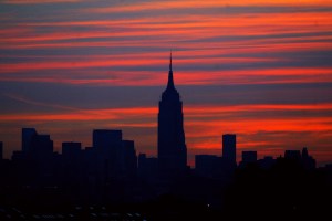 Manhattan skyline is dark as the sun comes up on the morning